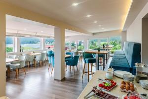 a restaurant with tables and chairs and windows at Ardo Spa Hotel and Restaurant in Sarnitsa