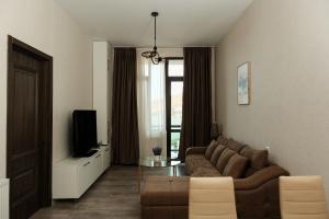 a living room with a couch and a tv at HD Didveli Apartment in Bakuriani