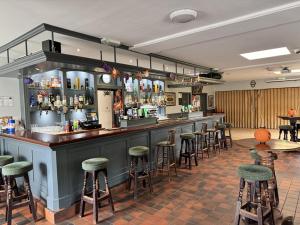 Un bar en un restaurante con taburetes. en Brú na Dromoda/Dromid Hostel, en Killeenleagh Bridge