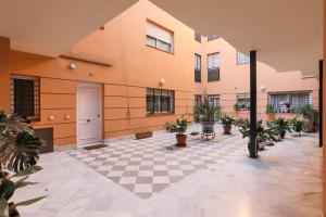 a courtyard with potted plants in a building at Fabled Parking in Seville