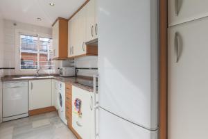 a kitchen with white appliances and a refrigerator at Fabled Parking in Seville