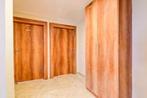 Una habitación vacía con armarios de madera en una casa. en Super Hotel O SHANTINIKETAN, en Calcuta