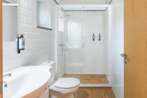 Un baño blanco con ducha y WC. en Casa da Ti Mónica, en Zambujeiras