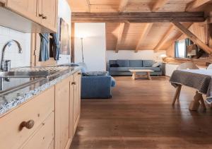 Una cocina y una sala de estar con un sofá azul. en Plazores, en San Vigilio Di Marebbe 22 fotos más