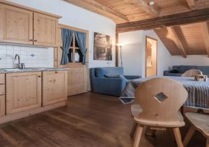 Una cocina y una sala de estar con una mesa y una silla. en Plazores, en San Vigilio Di Marebbe