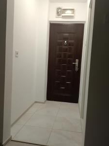 a black door in a hallway with a tile floor at Apartament Milcov in Galaţi