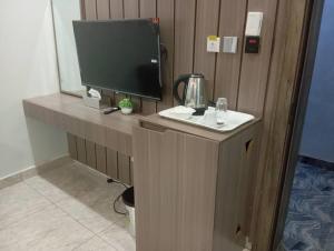 a desk with a monitor and a television on it at Walijam Bloom Luxury Suites in Kaduna +6 photos