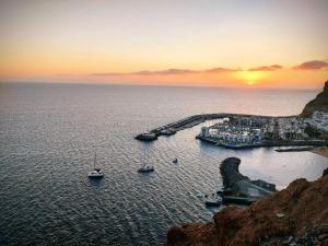 a sunset over a harbor with boats in the water at Vv Estrella in Puerto de Mogán +4 photos