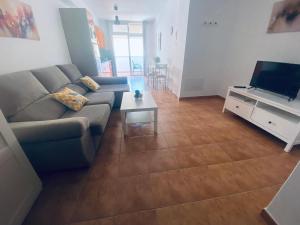 a living room with a couch and a tv at Vv Estrella in Puerto de Mogán