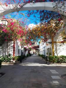 a street with white houses with pink flowers at Vv Estrella in Puerto de Mogán