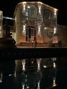 Ein Steingebäude mit Beleuchtung vor einem spiegelnden Teich in der Unterkunft Siwa desert palace in Siwa + 4 Fotos