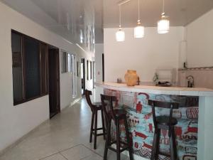 a kitchen with a bar with chairs and a counter top at Casa La Ceiba in San José del Guaviare