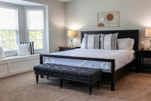 a bedroom with a bed with a bench in it at Sojourn Delightful Family Home Sleeps 6 in Norfolk