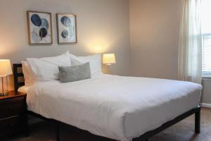 a bedroom with a large white bed with two lamps at Sojourn Delightful Family Home Sleeps 6 in Norfolk