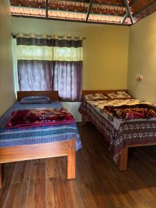 a bedroom with two beds and a window at Estate stay near Dubare elephant camp, friendly for remote workers in Siddapur