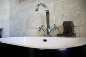 ein weißes Waschbecken mit einem Wasserhahn in einem Badezimmer in der Unterkunft Coach House. Falcon Mews in Bude + 26 Fotos