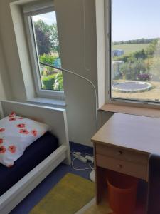 a room with a bed and a desk and a window at Ferienwohnung Ferienzimmer,nahe Rostock, Bentwisch Ot Albertsdorf bis 7 Personen in Bentwisch