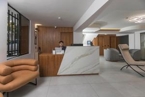 メデジンにあるHotel Balcones del Estadioの事務所の窓口に座る女 +158枚の写真