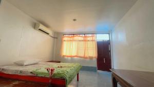 a small bedroom with a bed and a window at OYO 75596 The Sirisuk House in Ban Nong Nae