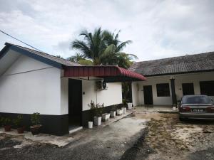 a car parked outside of a building with a palm tree at OYO 91244 Aufa Chalet in Kampong Ru Tujoh