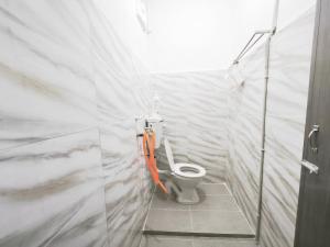 a white bathroom with a toilet in a room at OYO 91244 Aufa Chalet in Kampong Ru Tujoh
