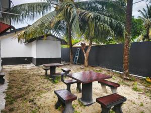 a group of picnic tables and benches next to a building at OYO 91244 Aufa Chalet in Kuala Terengganu