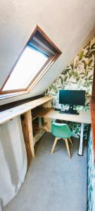 ein Büro im Dachgeschoss mit einem Schreibtisch und einem Computer in der Unterkunft Studio Amboise, parking, terrasse et jardin in Amboise