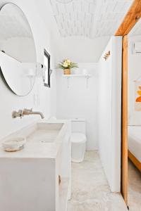 a white bathroom with a sink and a mirror at Downtown SURF SHACK- steps from main surf break in Sayulita