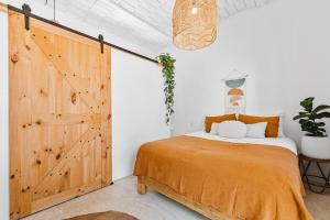 a bedroom with a sliding barn door and a bed at Downtown SURF SHACK- steps from main surf break in Sayulita