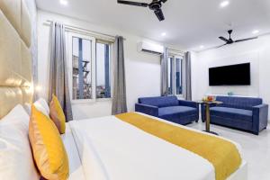 a bedroom with a bed and a couch and a tv at Hotel Travana Stay at Pitampura in New Delhi +24 photos