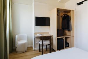 una habitación con un escritorio, una silla y una cama en Atipico Madrid, en Madrid