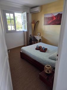 a bedroom with a bed with two slippers on it at Appart Cocotiers in La Saline les Bains
