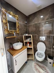 een badkamer met een wit toilet en een spiegel bij Tahari Villas in Buyukcekmece