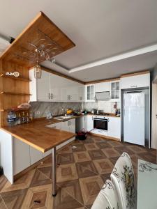 een keuken met witte kasten en een houten aanrechtblad bij Tahari Villas in Buyukcekmece