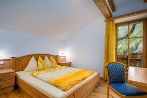 a bedroom with a bed and a chair and a window at Wieserhof Vals in Valles