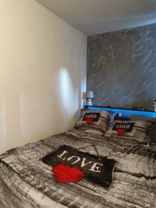 a bedroom with a bed withlove pillows on it at Studio dans résidence avec piscine à 50m de la mer in Roquebrune-Cap-Martin
