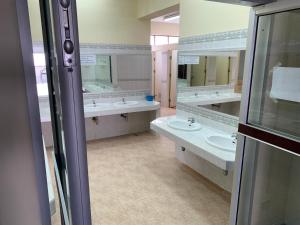 een badkamer met 3 wastafels en 2 spiegels bij Agnes Haven in Ban Khlong Haeng +8 foto's