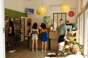 un groupe de personnes debout autour d'un comptoir dans un magasin dans l'établissement Camping La Mignardière, à Ballan-Miré