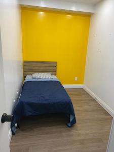 een bed in een kamer met een gele muur bij Private Room In Cambridge B8UP in Cambridge