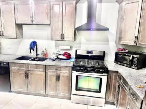 een keuken met houten kasten en een kookplaat met oven bij Private Room In Cambridge B8UP in Cambridge