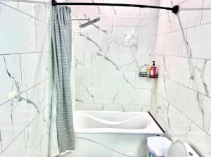 een witte badkamer met een bad en een douche bij Private Room In Cambridge B8UP in Cambridge