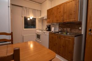 a kitchen with wooden cabinets and a wooden table at Mission Guesthouse in Gäddnäs