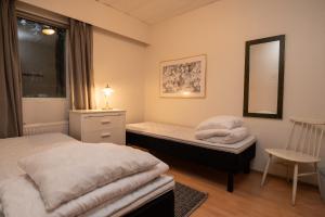 a bedroom with two beds and a mirror and a chair at Mission Guesthouse in Gäddnäs