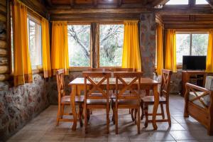 a dining room with a wooden table and chairs at Cabañas en Nono La Soñada in Nono