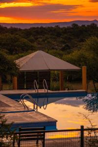 a swimming pool with a tent and a sunset at Cabañas en Nono La Soñada in Nono