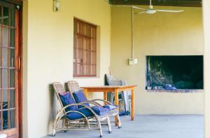 two chairs and a table in a room at Asher Riverside Cottages in Bonnievale