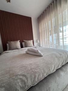 a bedroom with a large white bed with a window at BlueBreak Aourir in Aourir +26 photos