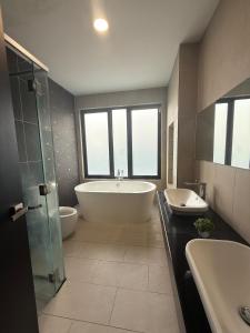 a bathroom with a tub and two sinks and a bath tub at The Garden Twelve Homestay in Putrajaya