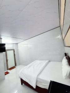 a white bed in a room with a ceiling at Vinh Hotel in Thốt Nốt
