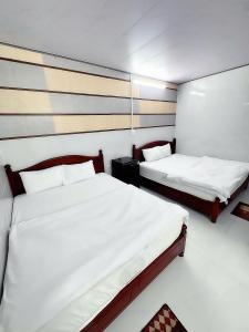 two beds in a small room with two beds sidx sidx sidx at Vinh Hotel in Thốt Nốt +10 photos